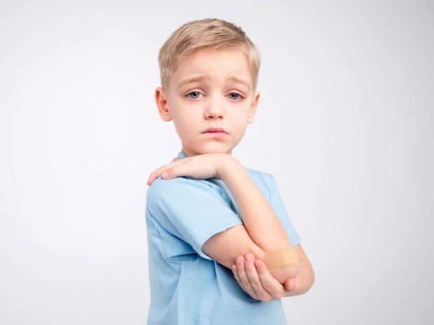 ragazzino triste si tocca il gomito dolorante