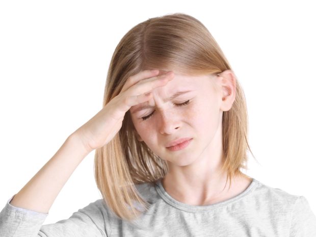 bambina si tocca la testa dolorante
