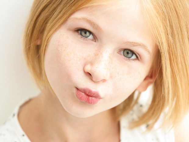 volto di bambina con lentiggini sul naso e sulle guance