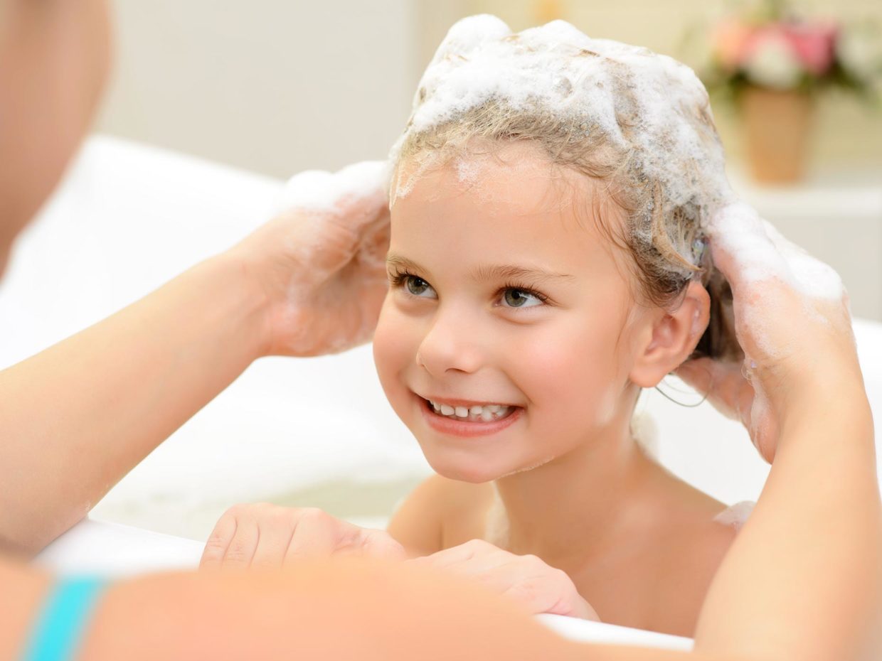 mamma lava i capelli della figlia nella vasca
