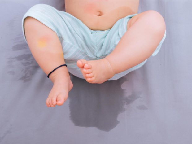 neonato su letto bagnato dalla pipì