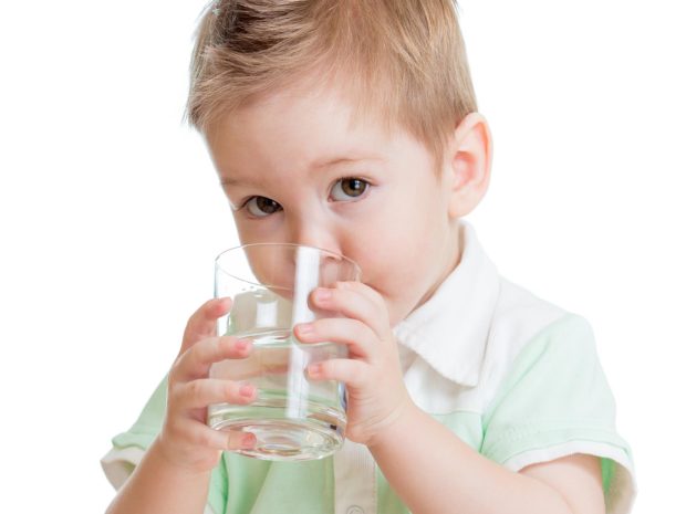 bambino beve un bicchiere d'acqua