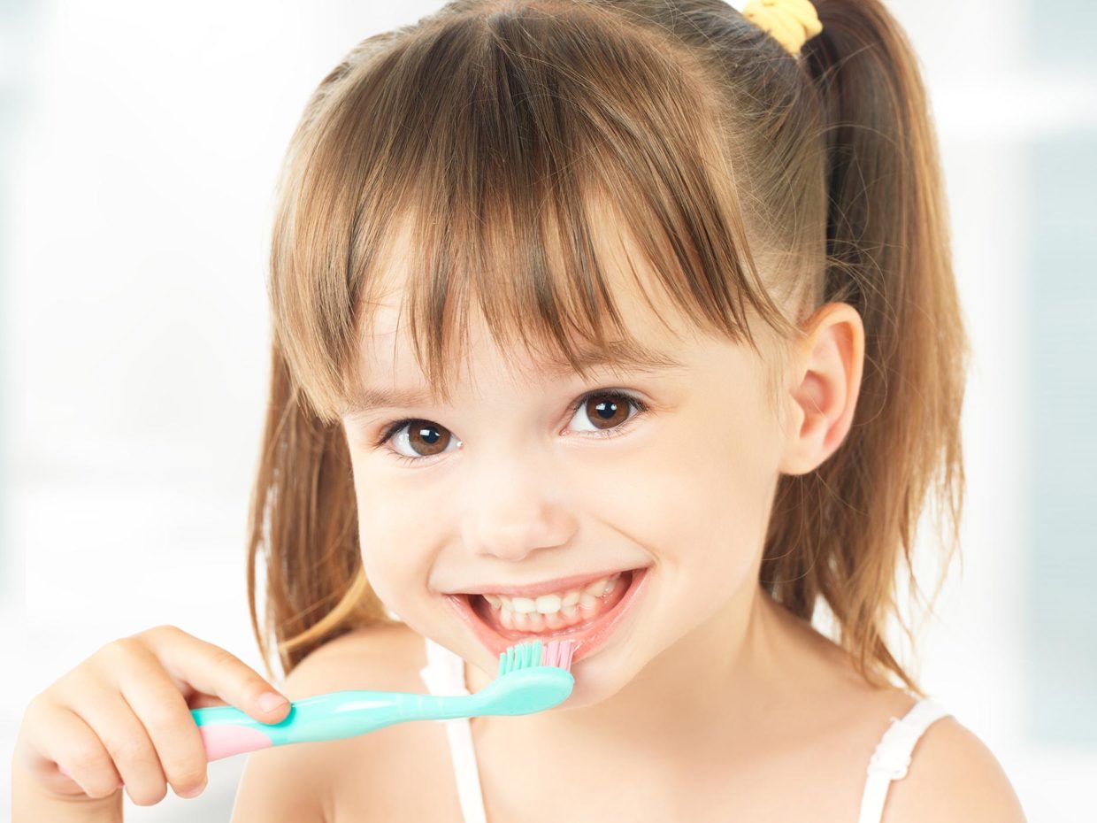 bambina con codine si lava i denti