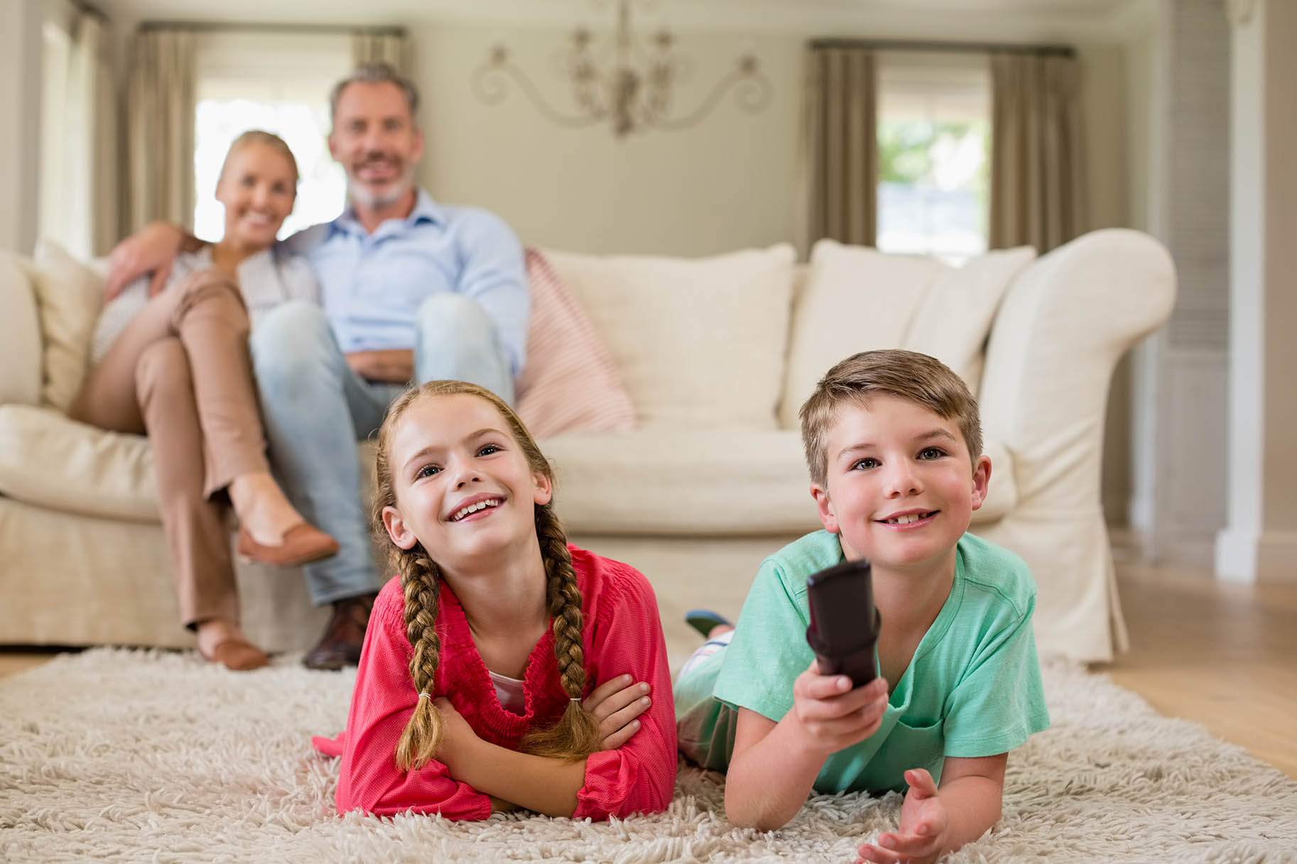 famiglia guarda la televisione nel salotto di casa