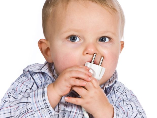 bambino con in bocca una presa elettrica