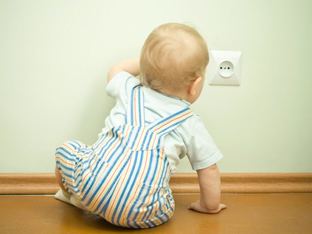 bambino si avvicina curioso alla presa della corrente elettrica