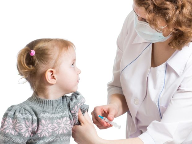 ragazzina si guarda con il medico che tiene in mano la siringa