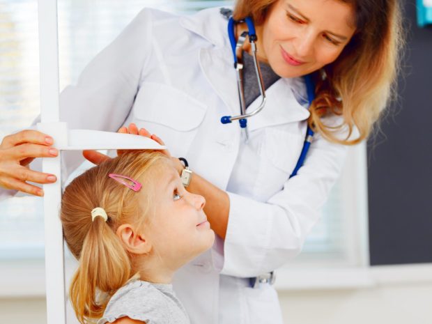la pediatra misura l'altezza di una bambina