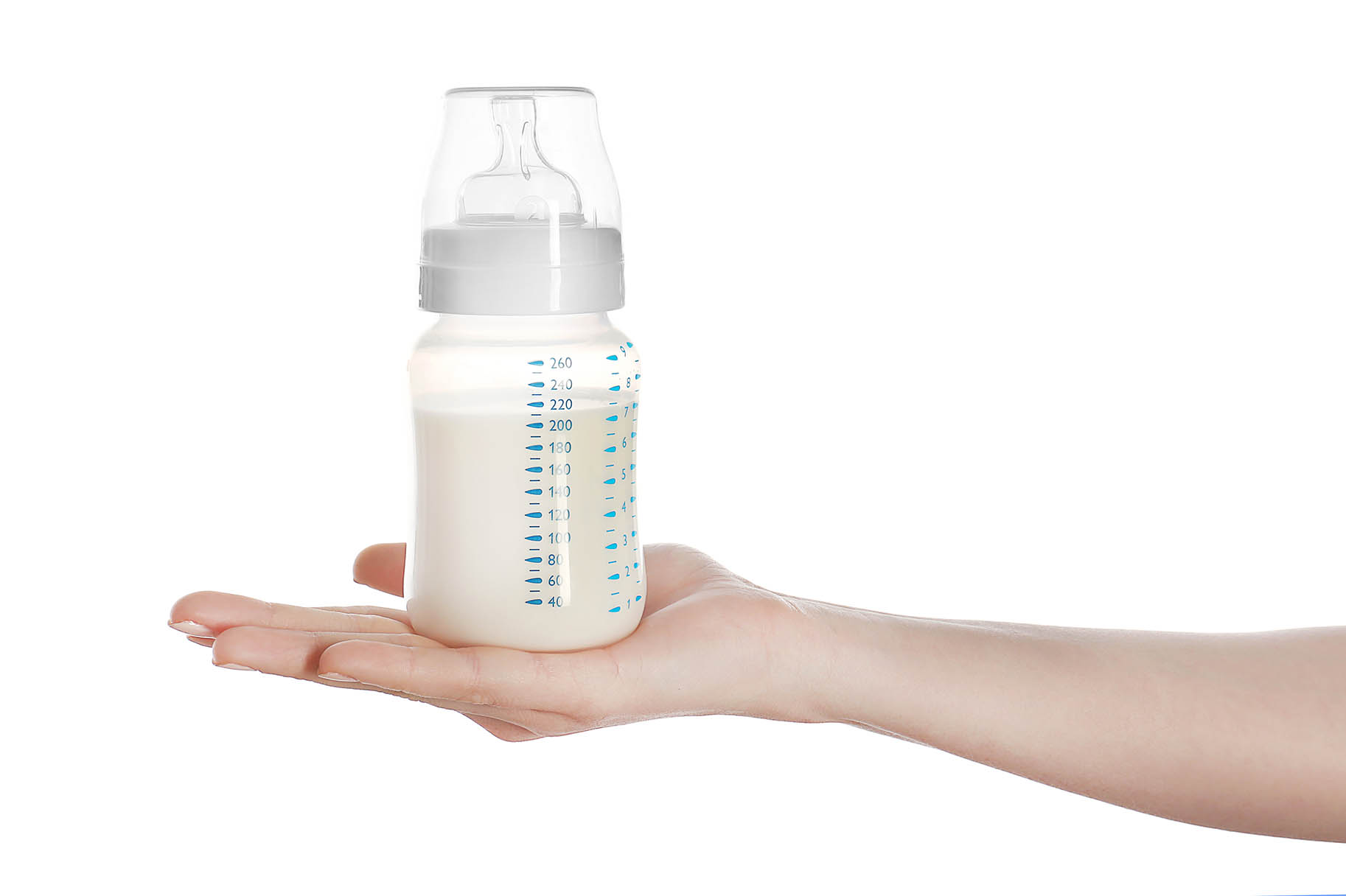 mano di donna tiene un biberon pieno di latte