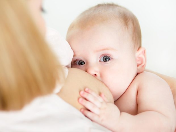 neonato mentre allatta al seno della mamma