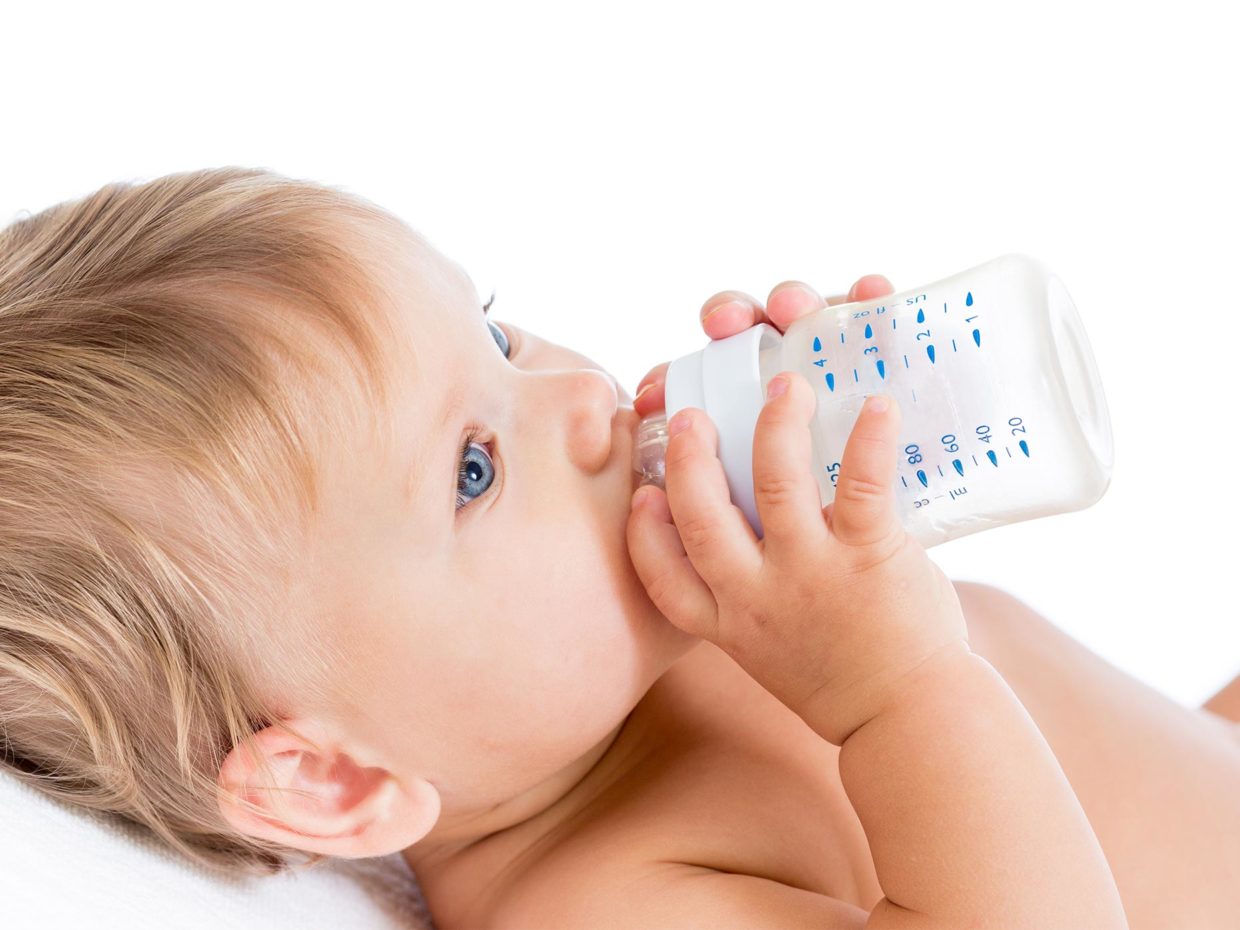 bambino beve il latte dal biberon