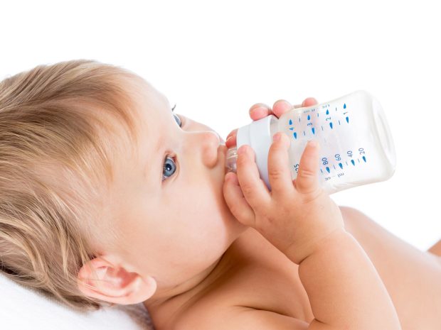 bambino beve il latte dal biberon