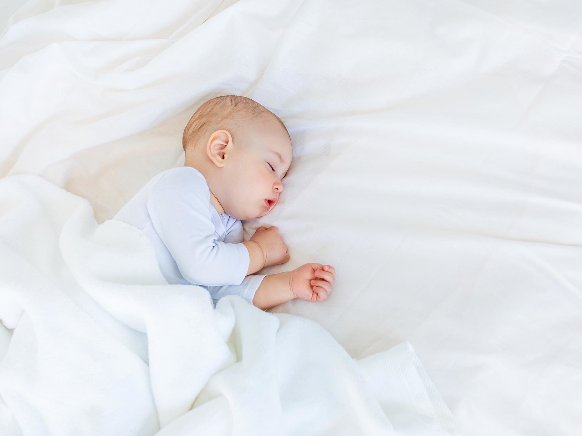 neonato dorme tranquillo sul letto