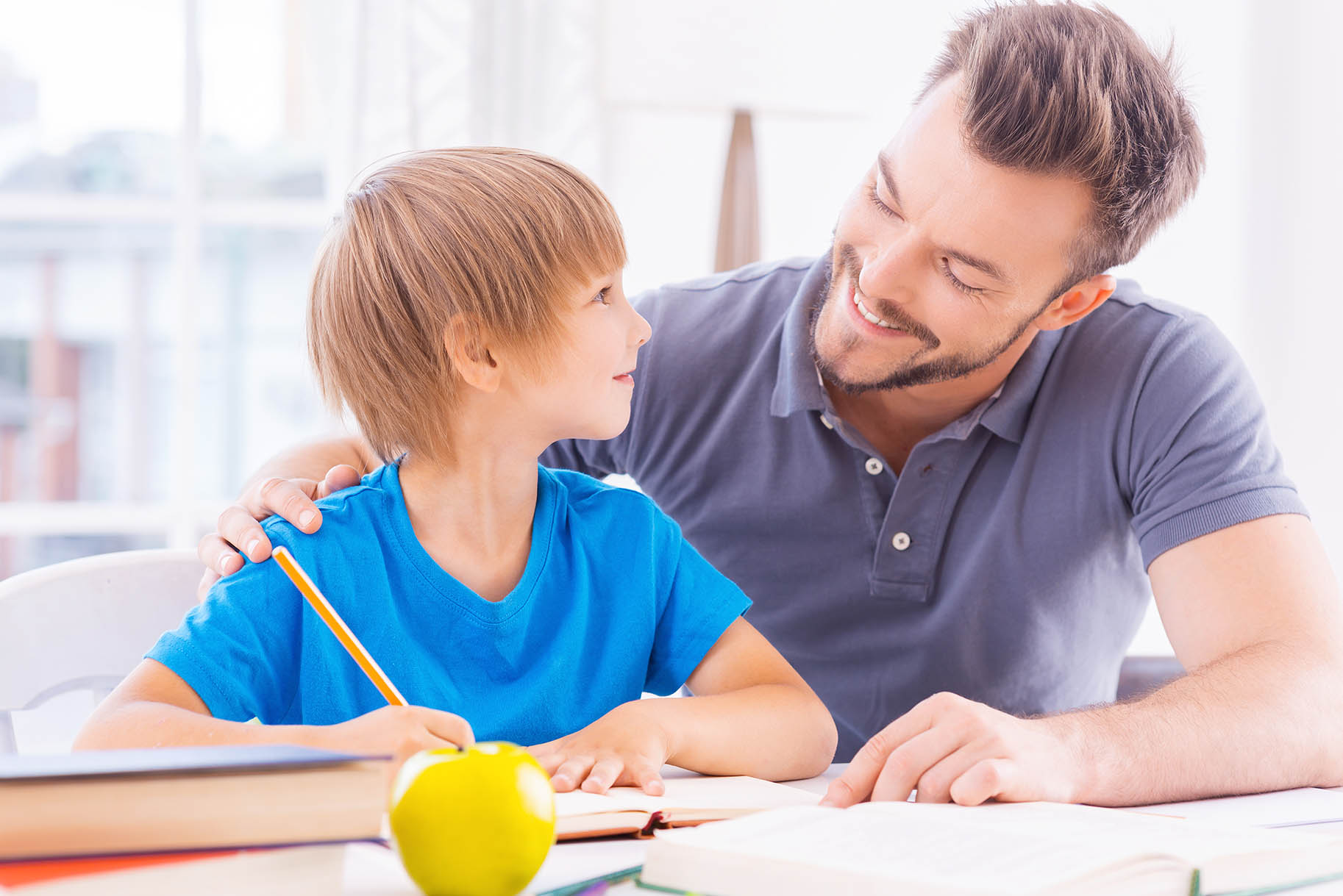 papà aiuta bambino a svolgere i compiti