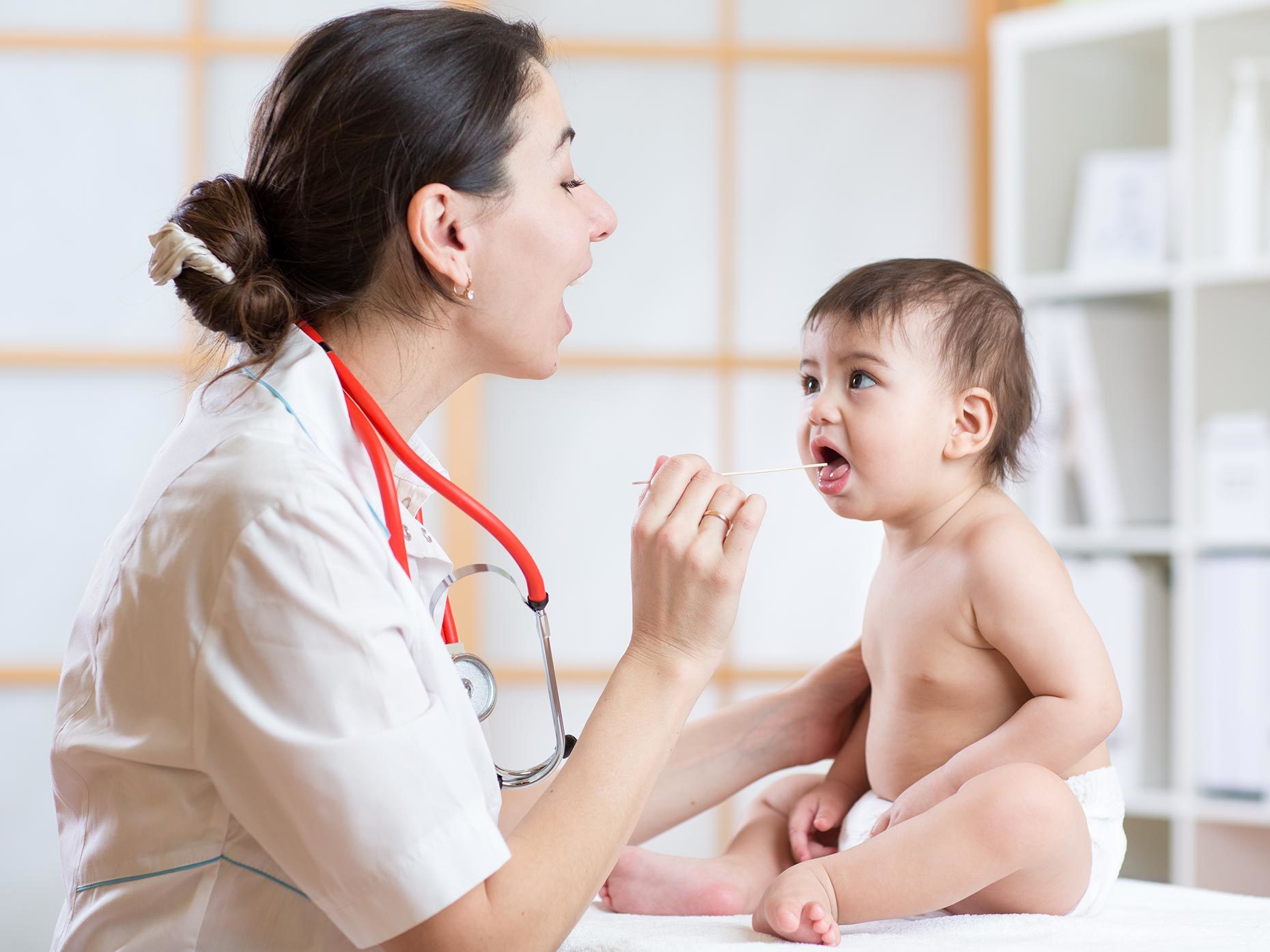 neonato dal pediatra che esegue visita alla gola