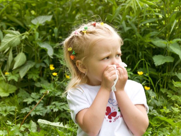 bambina bionda si soffia il naso