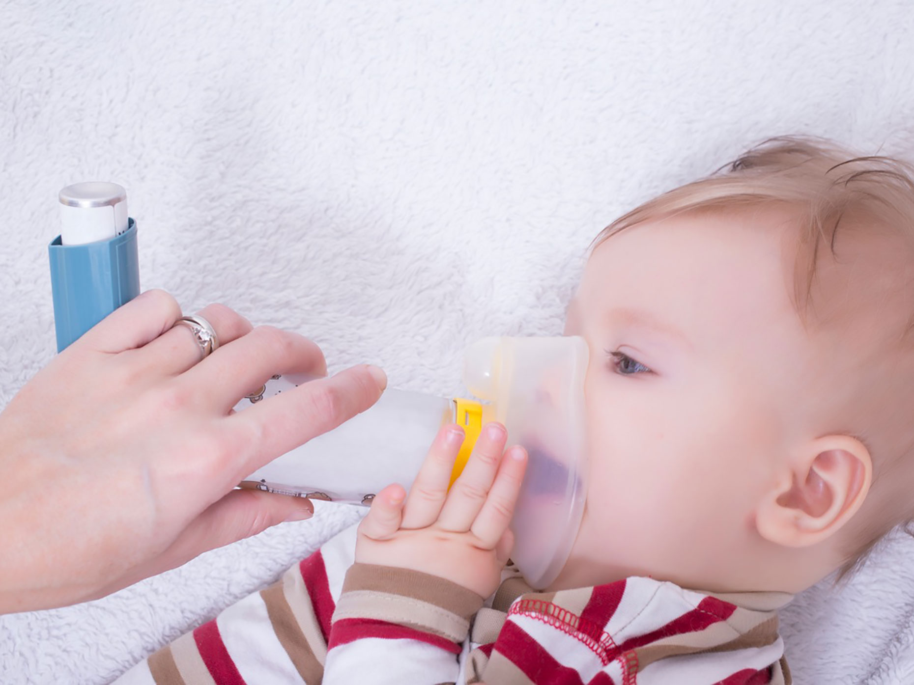 neonato utilizza con aiuto della madre distanziatore per inalatore spray