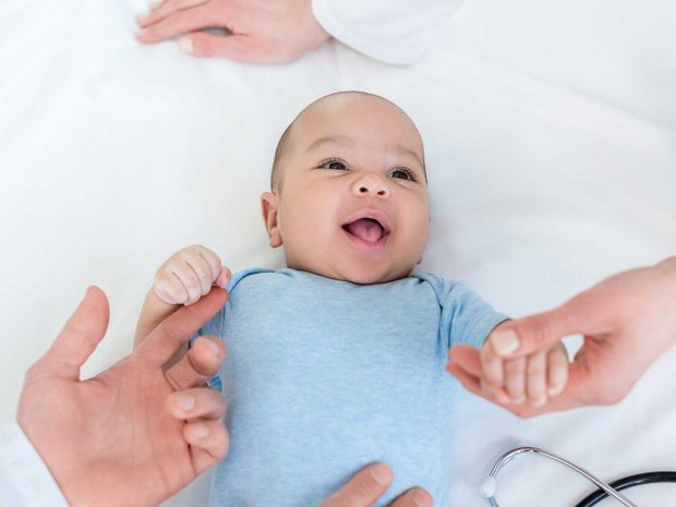 primo piano del bambino che ha lo sguardo rivolto verso il pediatra che lo sta visitando