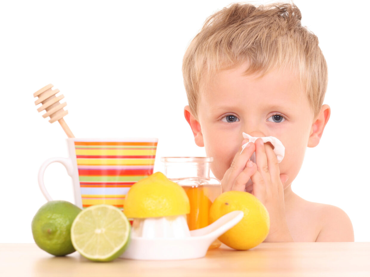 Bambino che assume frutta con vitamina C per il raffreddore