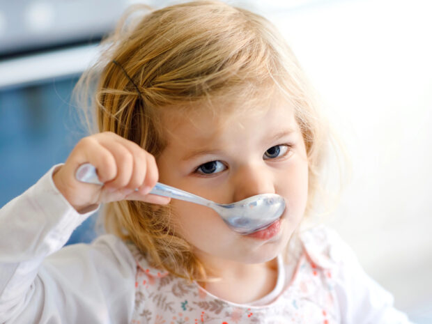 Bambina con mal di pancia che mangia in bianco