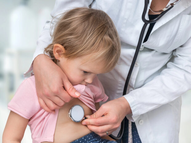 Pediatra che visita i polmoni di una bambina