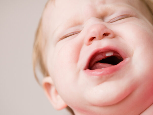 Bambino piccolo in fase di dentizione che piange per il dolore