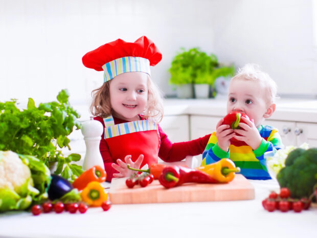 Bambini che assaggiano frutta e verdura di stagione