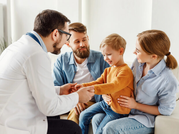 Pediatra con bambino e famiglia: concetto di Metodo Brazelton