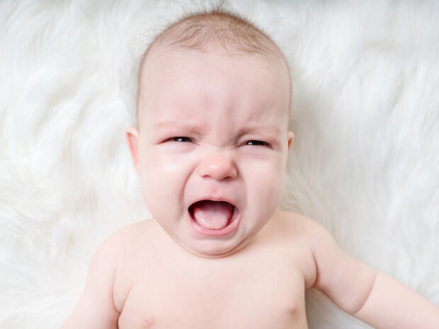 Bambino di 4 mesi che piange sveglio su una coperta: concetto di regressione del sonno